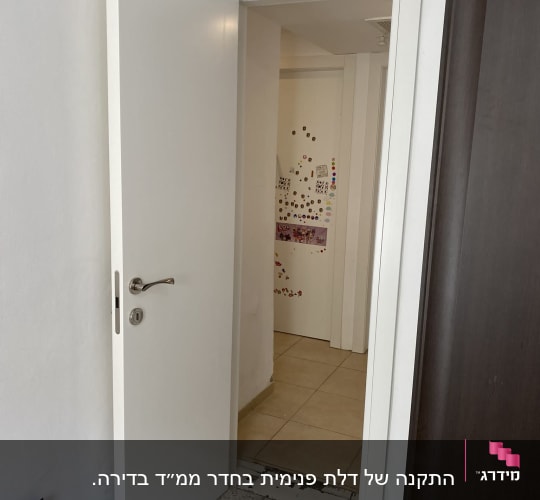 דלת לבנה פתוחה עם ידית כסופה